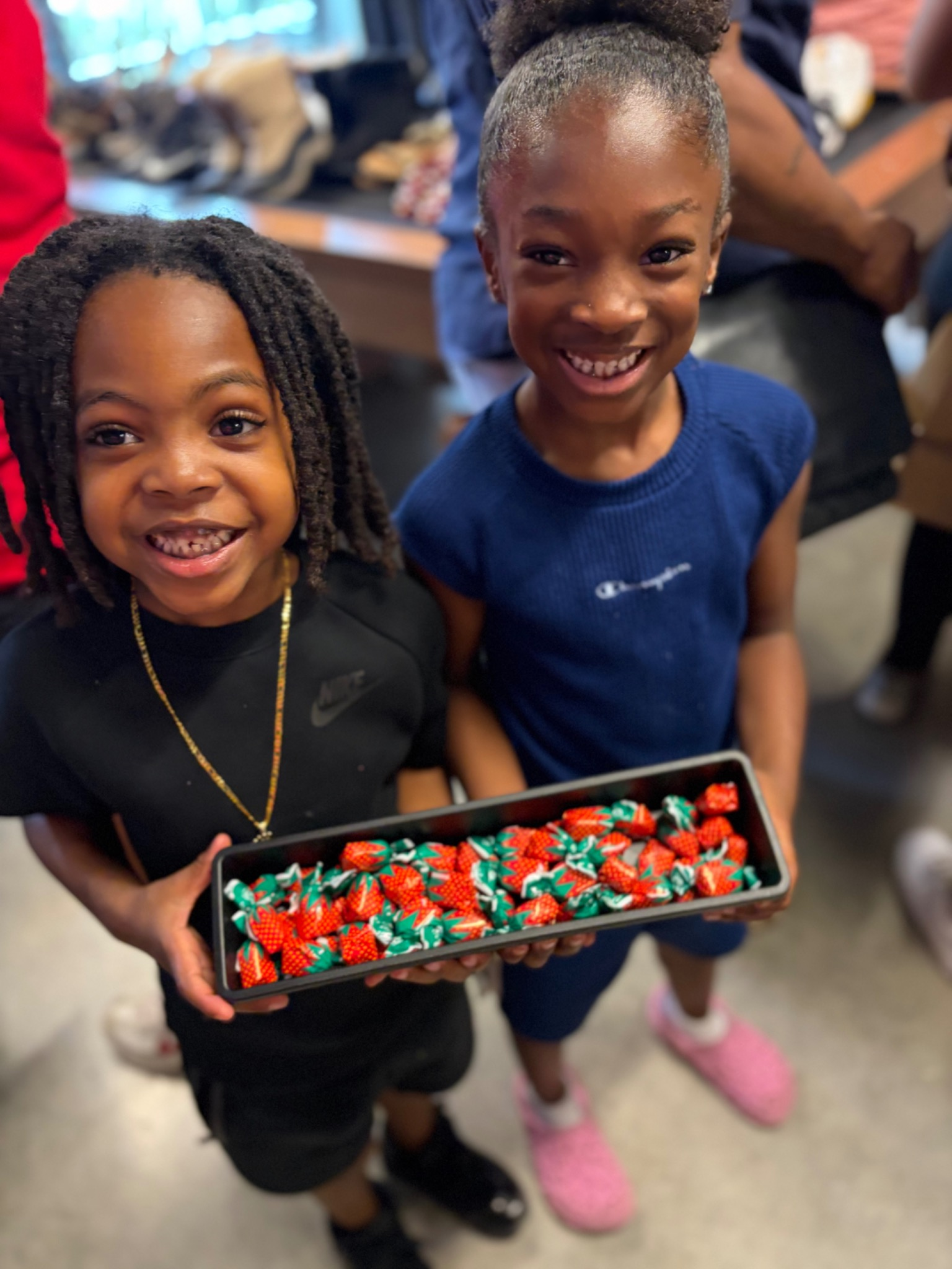 Two young children smiling and holding a tray of candy at the Fresh and Fly Bash