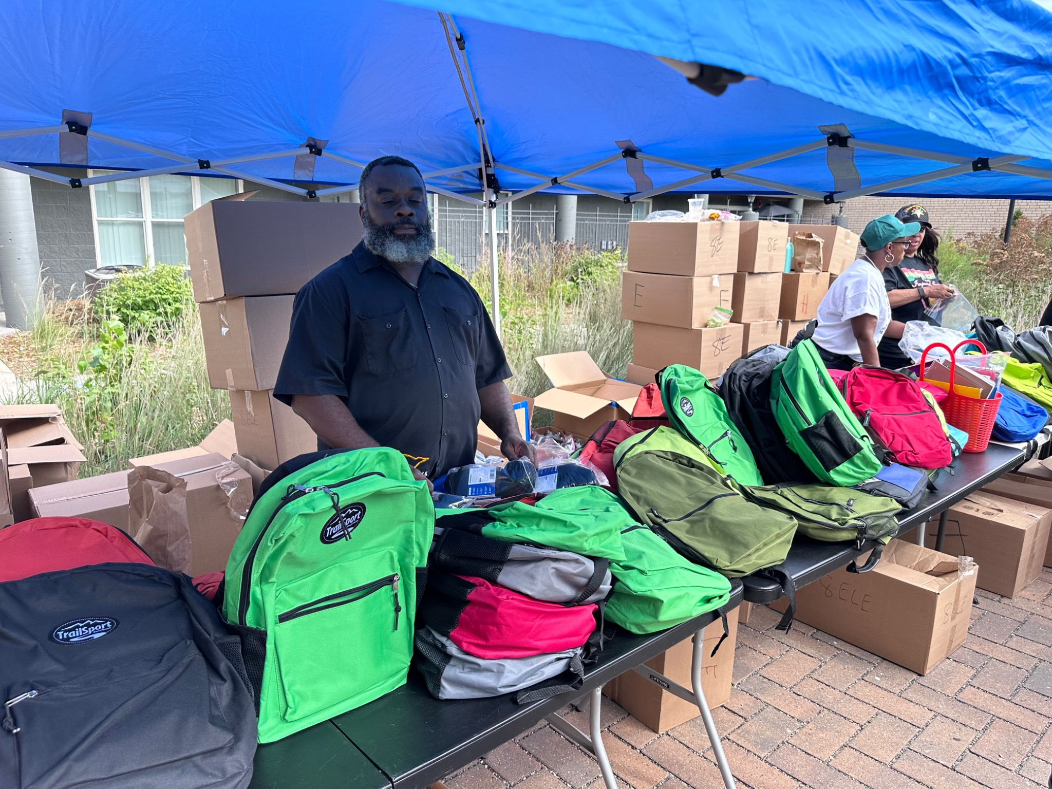 Volunteers distributing backpacks at the Fresh and Fly Bash