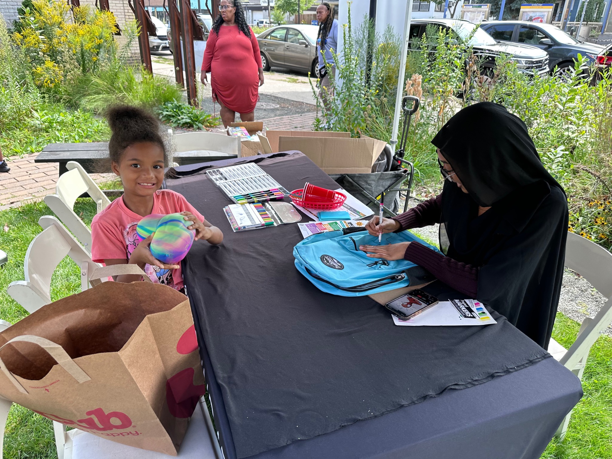 Child receiving a personalized backpack at the Fresh and Fly Back-to-School Bash