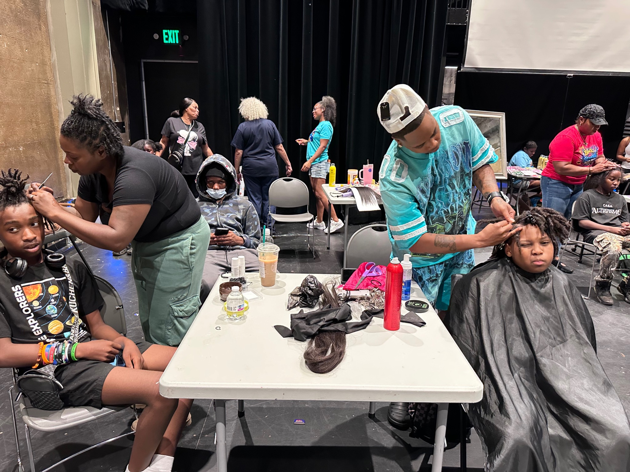 Hair stylists providing free services to youth and families at the Fresh and Fly Bash